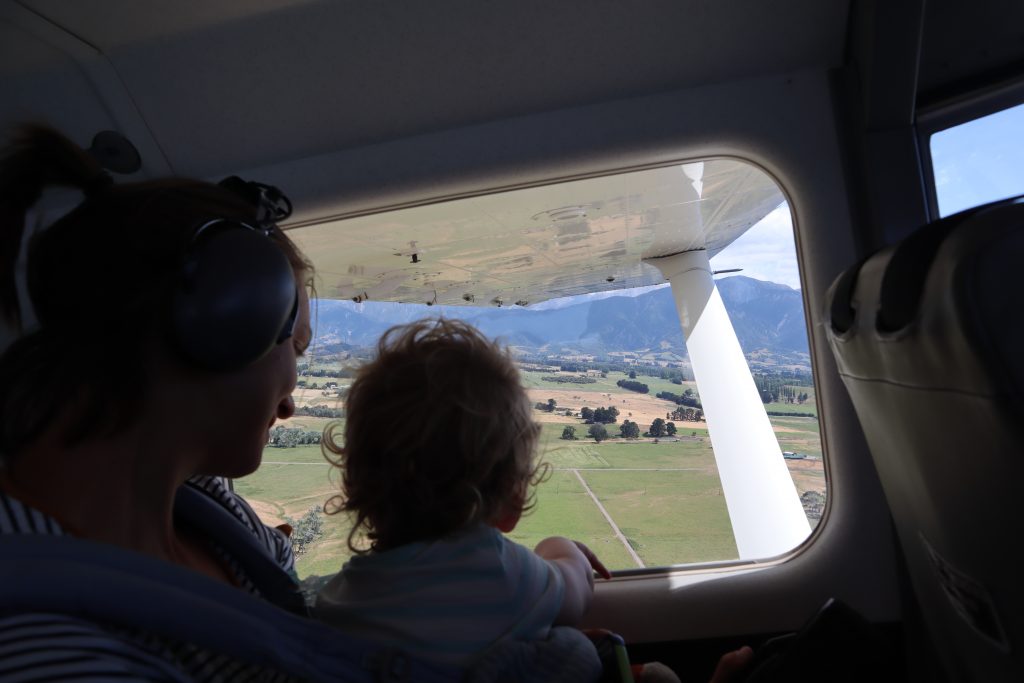 a toddler checking out the views of new zealand from a plane