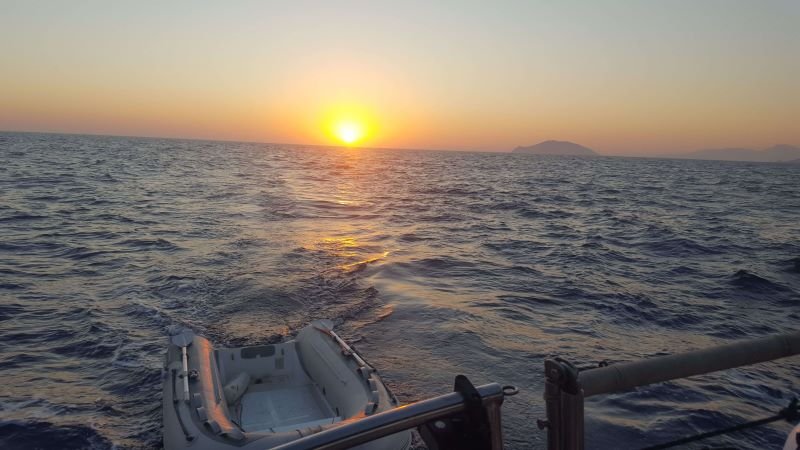 a sailboat sailing at sunset