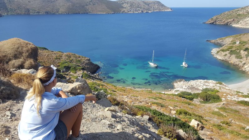 a girl with a small waterproof sailing bag in her pocket looking at her sailboat