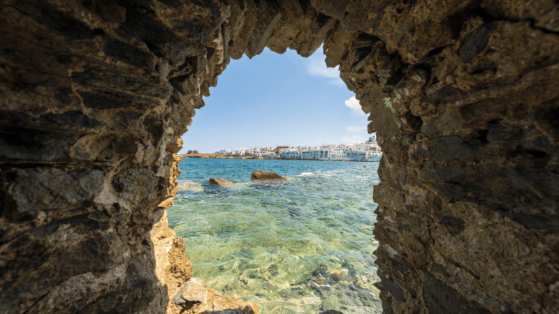 a stone window looking out onto views of some of the best beaches in paros