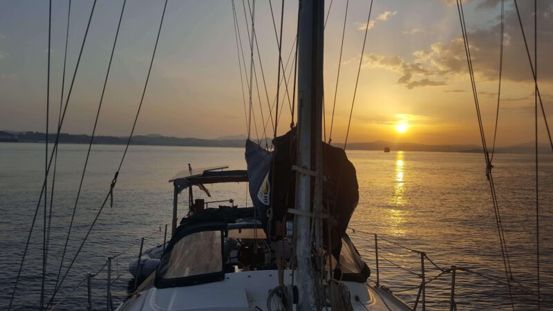 a sailboat with a sunset behind