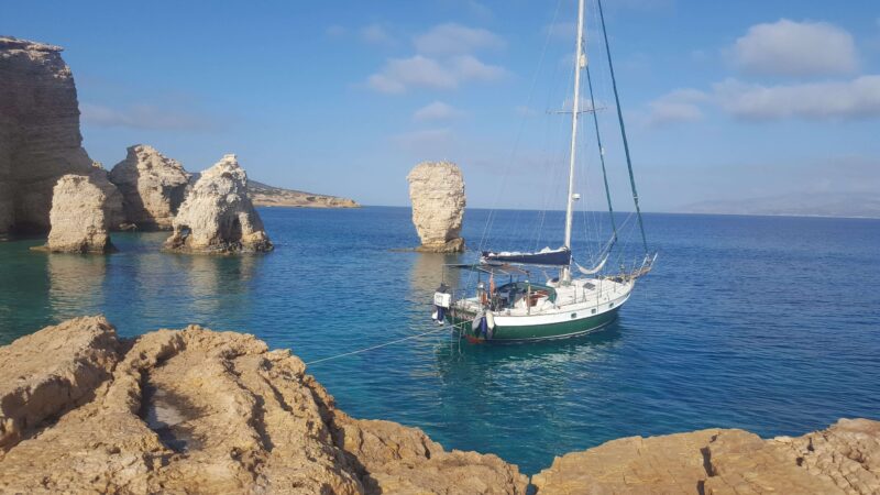 a green sailboat in a private anchorage