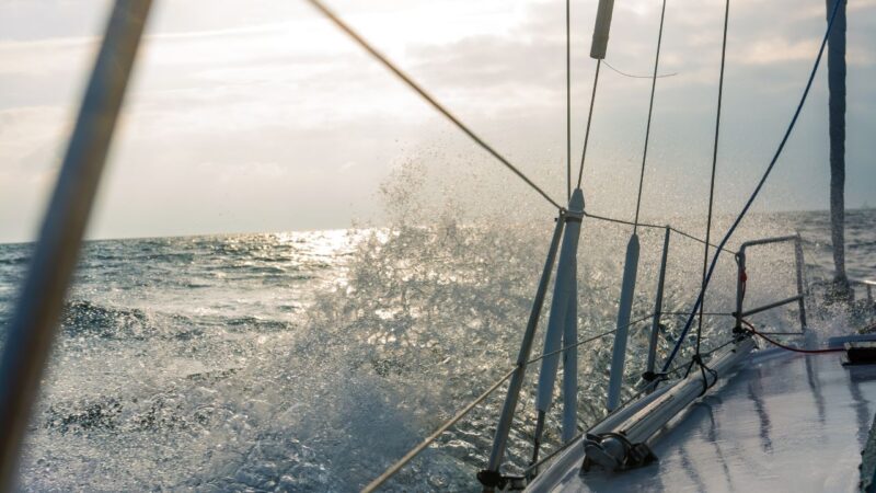 Waves breaking over the side of a sailboat