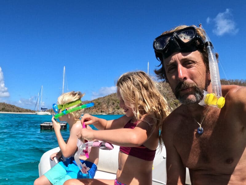 a man and his family going snorkelling from the trawler they live on.
