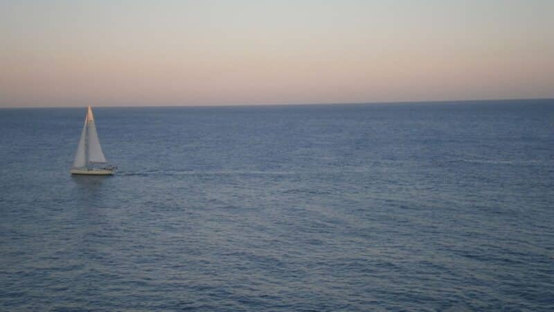 a sailing boat with full sails up crossing the atlantic ocean