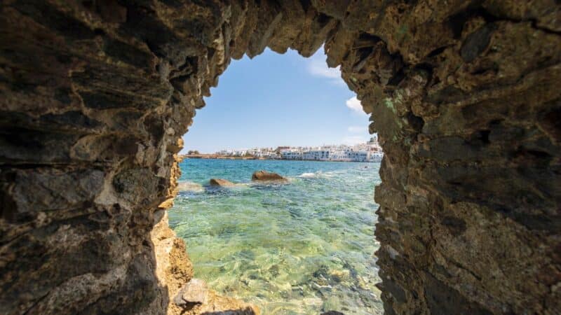 the sea through the window of an ancient ruin in one of the best beach towns in Greece