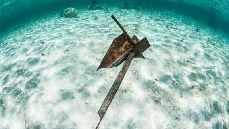 An anchor lying in sand on the sea bed