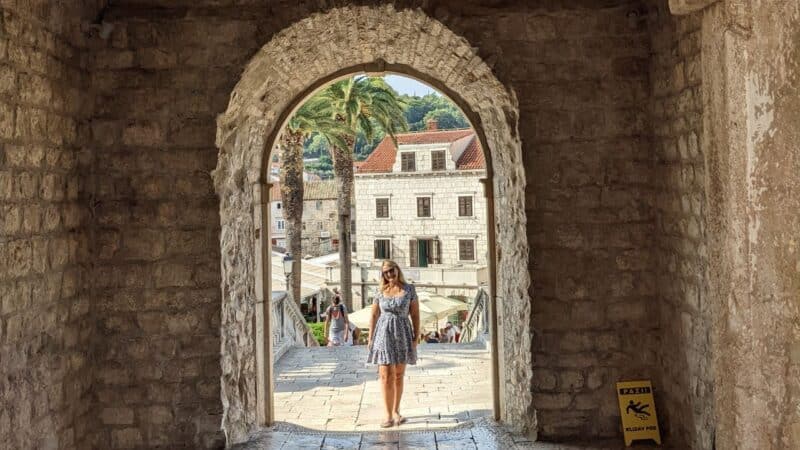 a girl stood in a doorway in korcula old town