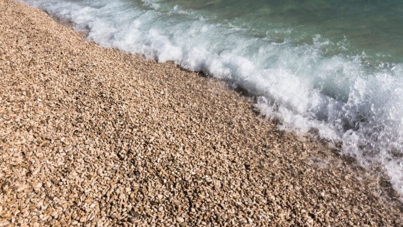 WATER RUSHING ONTO A STONE BEACH