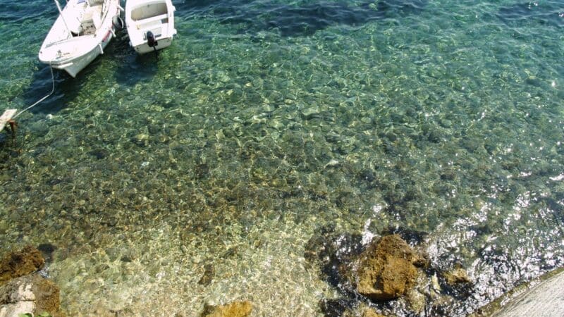 boats anchored in crystal clear water on Korcula island, Croatia