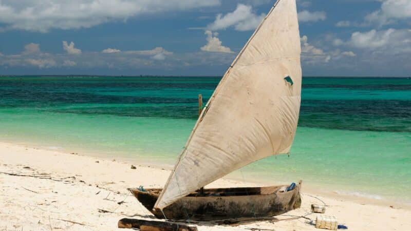 a traditional dhow boat on a beach in zanzibar