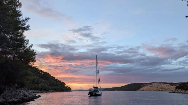 a sailboat in front of a sunset