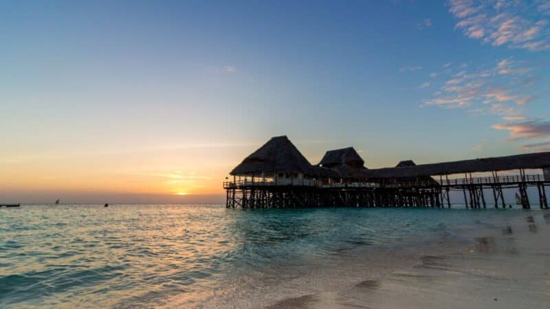 a pier out to sea as the sun sets
