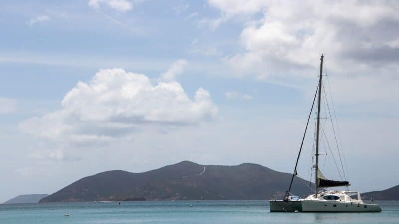 a catamaran anchored by a mountain