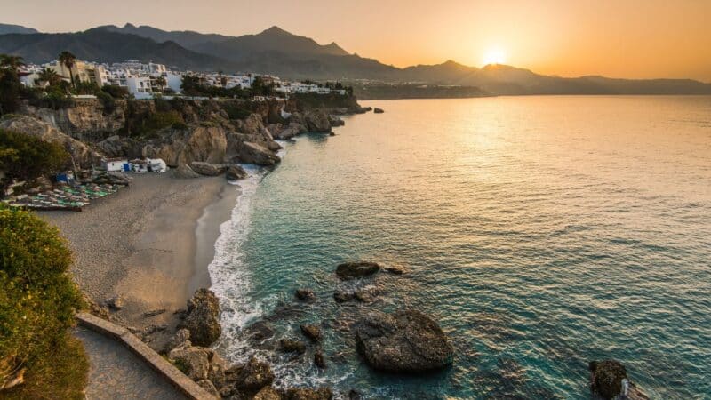 a pretty view of the sunset and beach in spain, where people feel safe