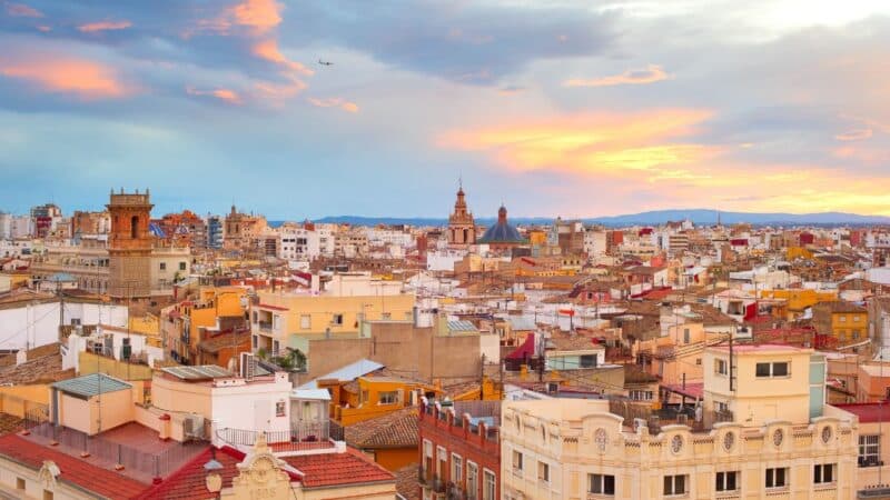 a view over the rooftops of barcelona city in spain, with lots of people wondering is spain safe
