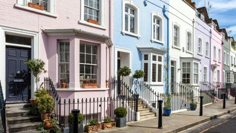 a pretty street of pastel coloured houses in a neighbourhood that is safe in London
