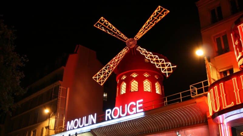 the moulin rouge building with the windmill lit up