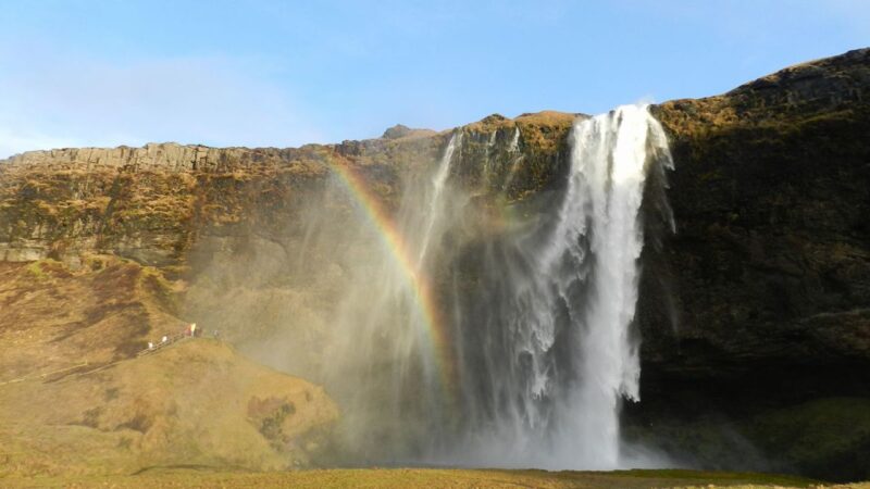 a waerfall in iceland with a rainbow in front of it